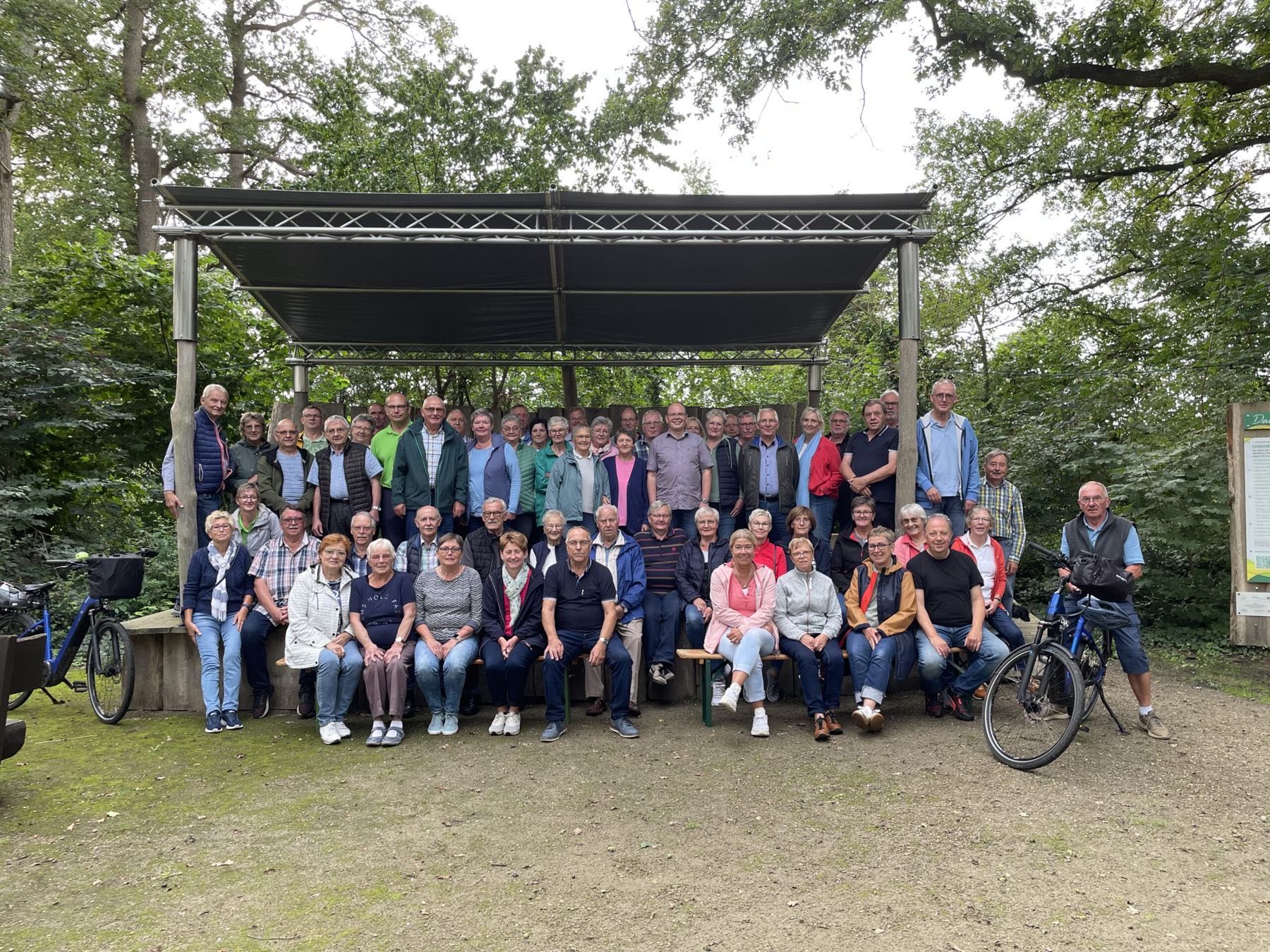 Gruppenfoto der Heimatfreunde vor der überdachten Bühne am Schlumps Backs