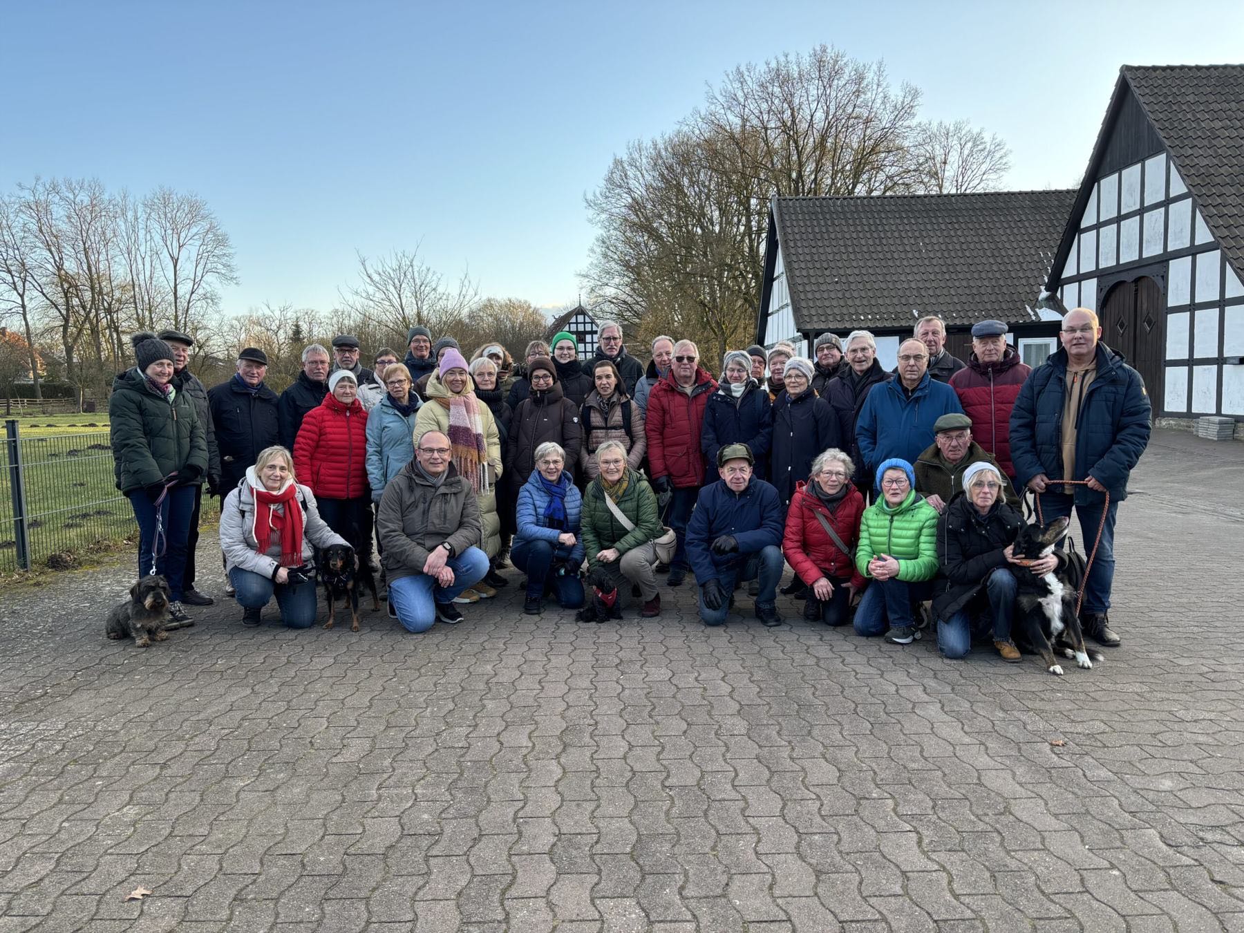 Große Gruppe der Heimatfreunde vor einem Fachwerkhof